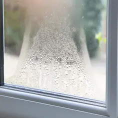 Para skrapla się na zewnętrznej stronie okna, tworząc krople wody.