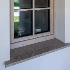 Elegancki parapet zewnętrzny z granitu, idealnie dopasowany do okna. Sprawdź, ile za montaż parapetów zewnętrznych.
