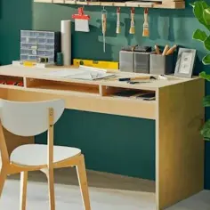 Drewniane biurko DIY z białym krzesłem, narzędziami i rośliną w doniczce.