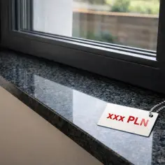 Parapet z granitu z metką cenową "XXX PLN" przy oknie.